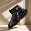 Stylish black 'Exodus' unique design sneaker suspended in mid-air, showcasing its chunky sole, advanced damping technology, and heighten design, perfect for making a bold fashion statement.