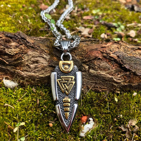 Valknut Gungnir Necklace featuring Odin's Spear with Rune Symbol and Ravens of Odin, adorned with a mesmerizing Labradorite gem, lying on a mossy surface.