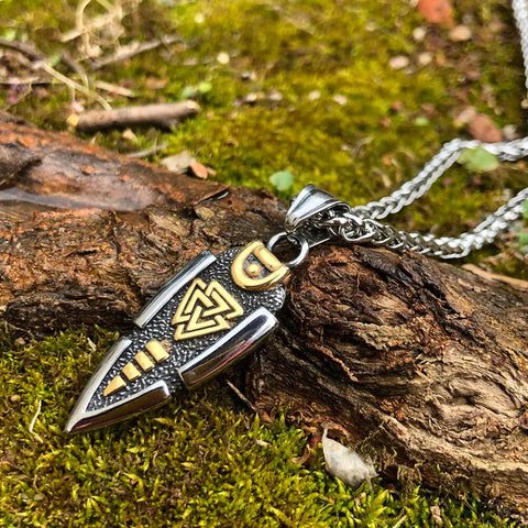 Valknut Gungnir Necklace featuring Odin's Spear with Rune Symbol and Ravens of Odin, adorned with a mesmerizing Labradorite gem, lying on a mossy surface.