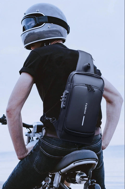 A man wearing a helmet and a black "Mochila" executive fashion bag on his back, sitting on a motorcycle, showcasing the bag's sleek design and comfortable fit.