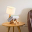 iRobot Shape Customizable Desk Lamp with a unique robot design, made from durable wood and fabric, adding a touch of fun and style to any room.