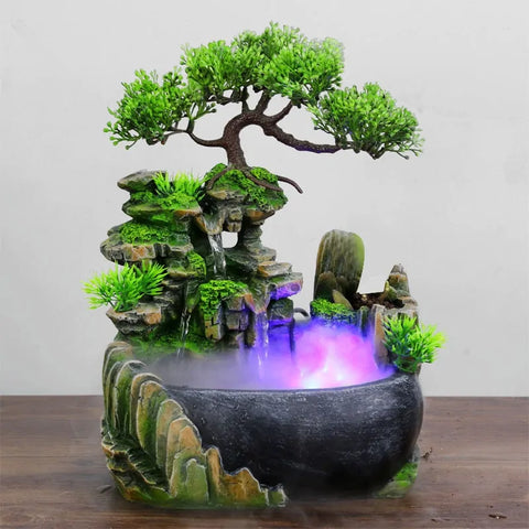 Inner Piece Waterfall Designer Fountain featuring a Feng Shui-inspired design with green plants, cascading water, and a mist effect in a black resin bowl.