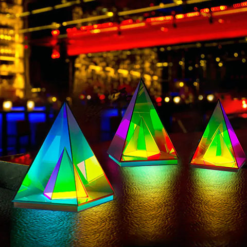 Three vibrant, triangular Infinity Lamps with futuristic designs, emitting colorful LED lights, placed on a sleek surface in a dimly lit room, creating a mesmerizing and modern ambiance.